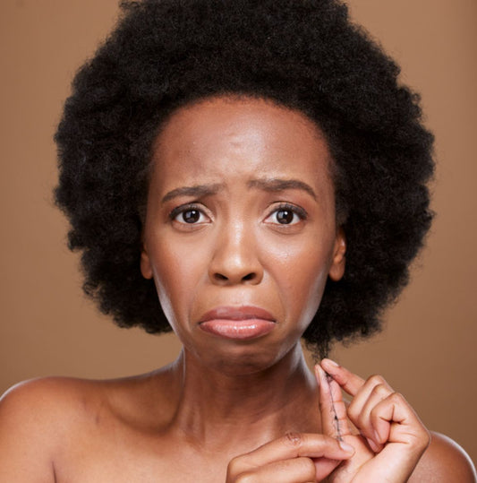 Illustration of hair shedding and breakage with hairbrush and hair strands.