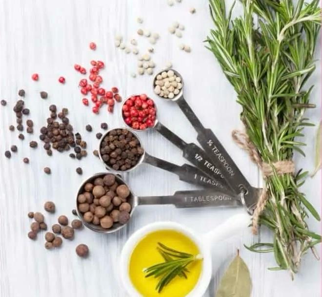 Rosemary sprigs beside a bottle of rosemary-infused oil, great for hair growth.