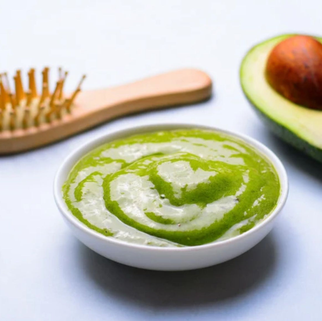 Person applying avocado hair mask for hydration and shine