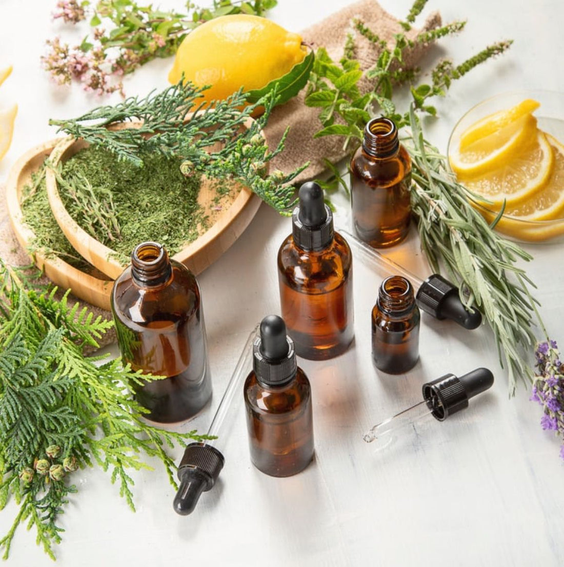 Rosemary oil for hair growth with rosemary sprigs on a wooden table