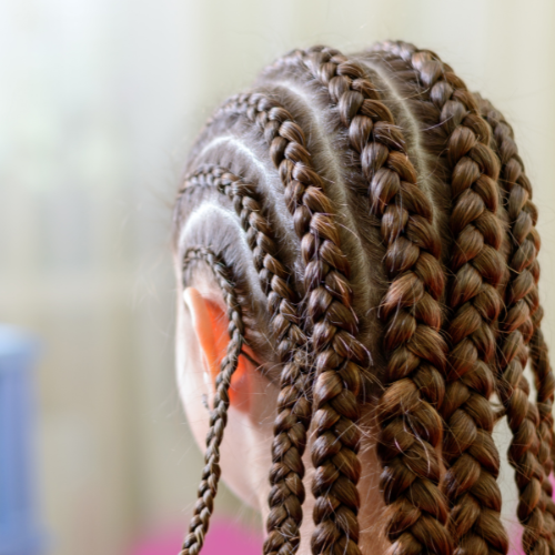 Woman styling hair with heatless braids