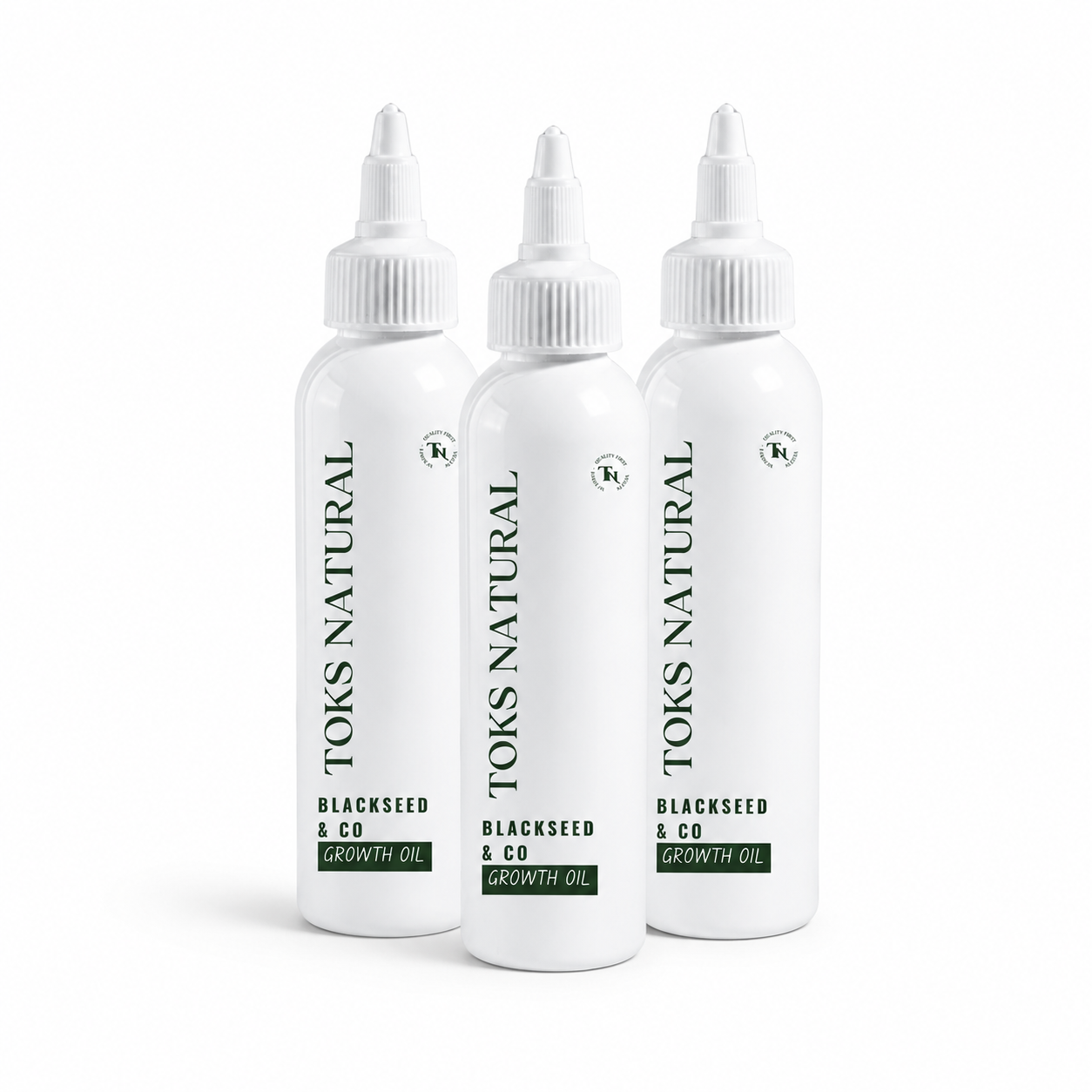Three bottles of Toks Natural Blackseed & Co Growth Oil on a white background