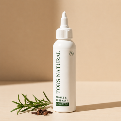 Toks Natural Cloves & Rosemary Growth Oil bottle with rosemary sprig and cloves on a beige background