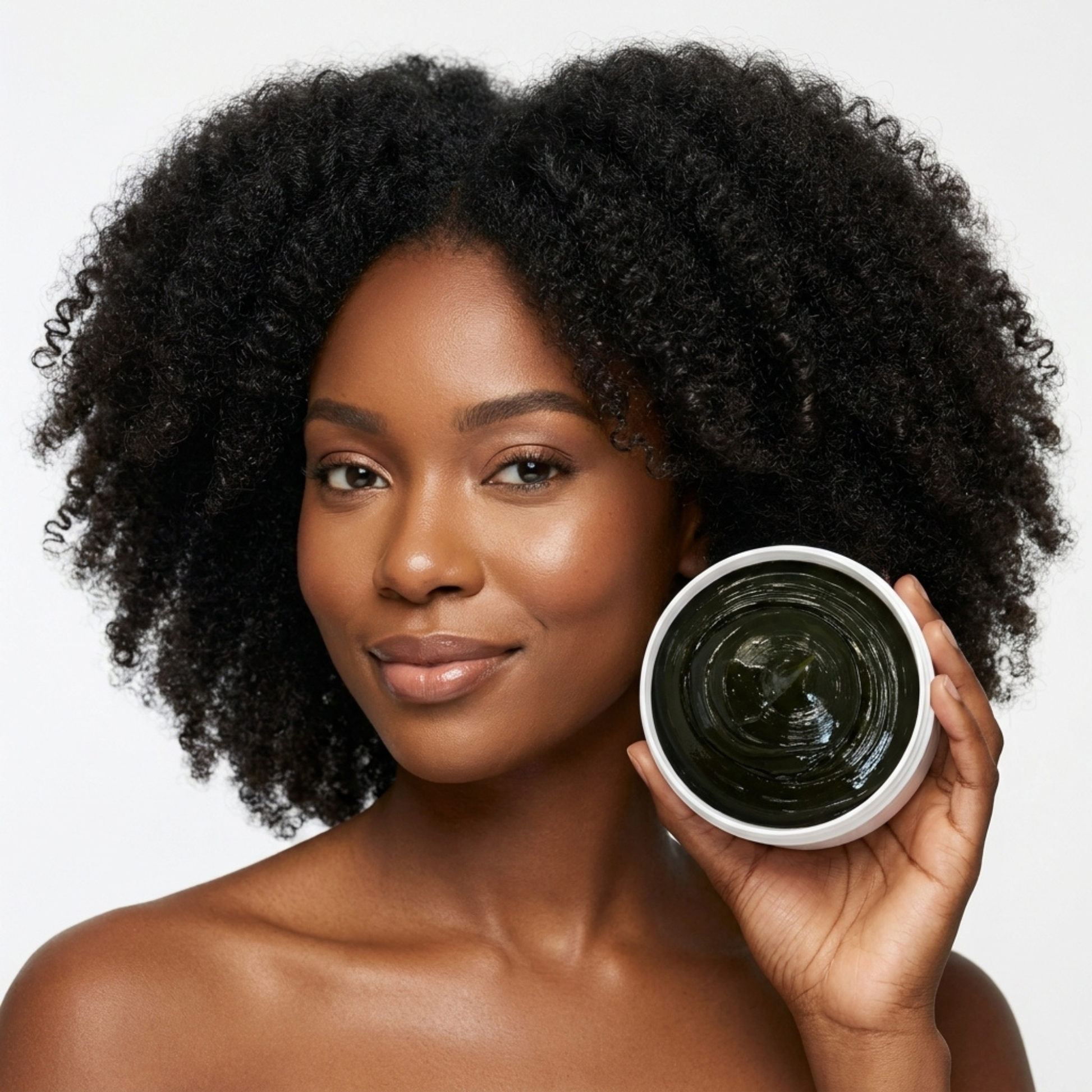 Woman holding a container of hair product with a plain background