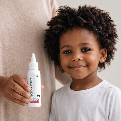 Child holding a bottle of Toks Naturals Kids product with a neutral background