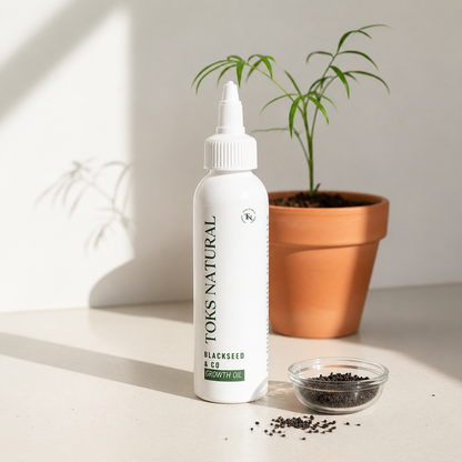 Toks Natural blackseed oil bottle on a light surface with a plant in the background