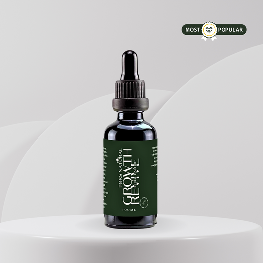 Bottle of 'Growth Revive oil' on a white pedestal with a gray background