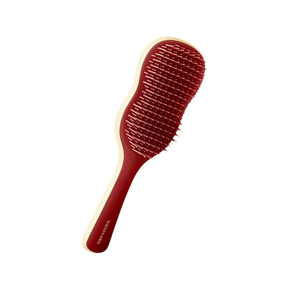 Red hairbrush with wooden handle on a white background