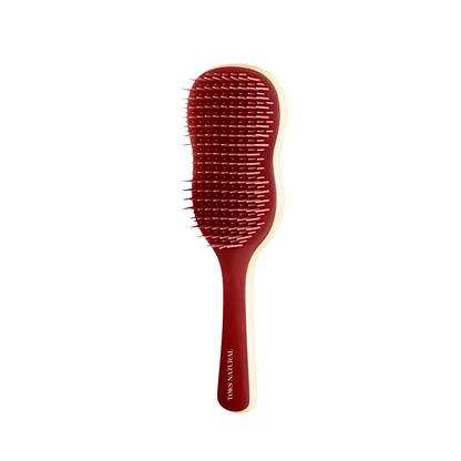 Red hairbrush with a white handle on a white background