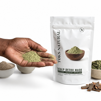A white stand-up pouch labeled 'Toks Natural Scalp Detox Mask' stands on a white surface, with a hand holding green powder in the foreground and small bowls of ingredients nearby.