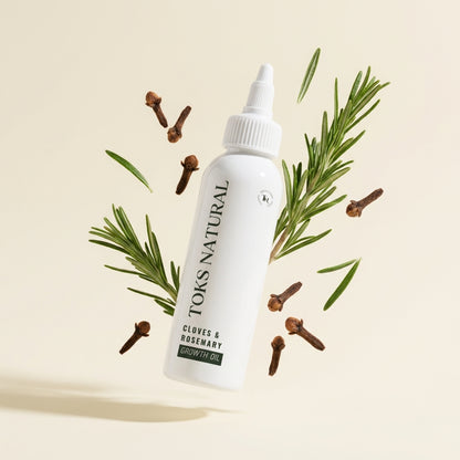 Toks Natural Cloves & Rosemary Growth Oil bottle with clove and rosemary leaves on a beige background