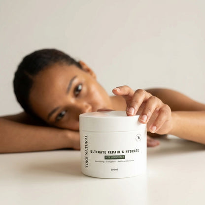 a lady with natural hair holding a jar of Toks natural ultimate deep conditioning treatment