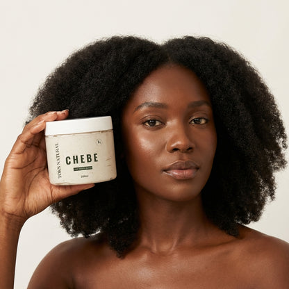 Woman holding a jar of 'Chebe' product with a neutral background