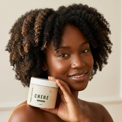 Woman holding a jar of 'Chebe' product with a neutral background