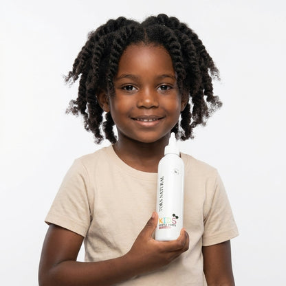 Child holding a bottle of Tork's Natural hair product against a white background
