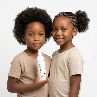 Two children holding a bottle of shampoo against a white background