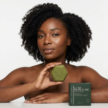 Woman holding a green hexagonal bar of soap with 'Lime Moisture' packaging on a white background