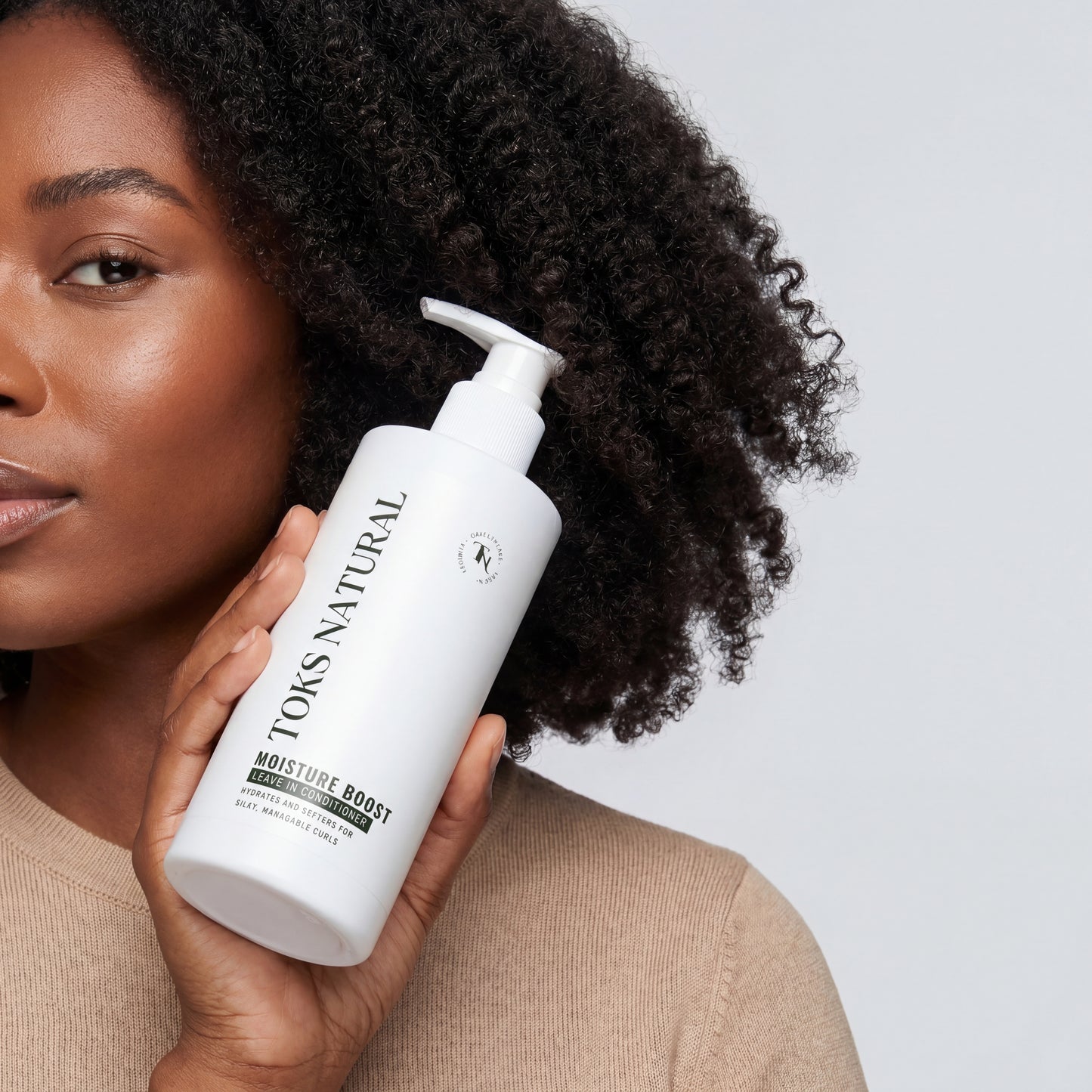 Woman holding a bottle of 'Toks Natural' product against a light background