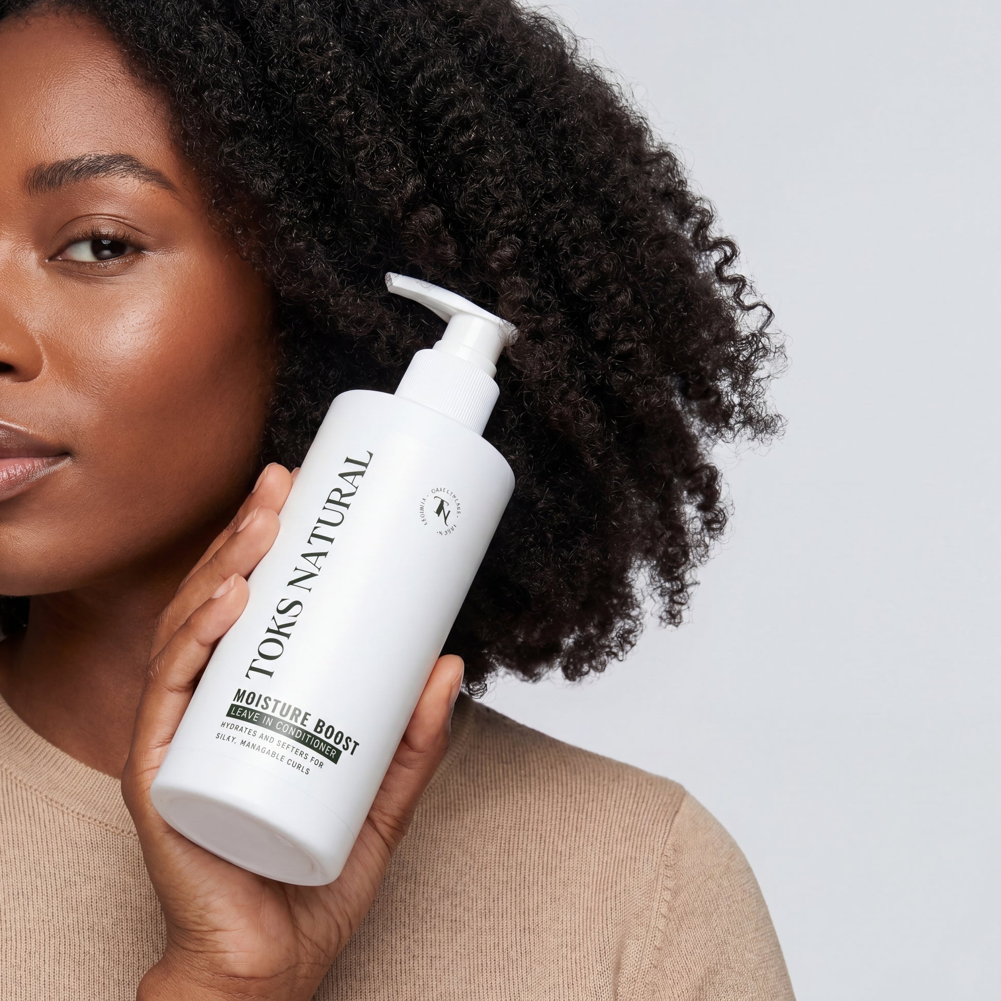 Woman holding a bottle of 'Toks Natural' product against a light background