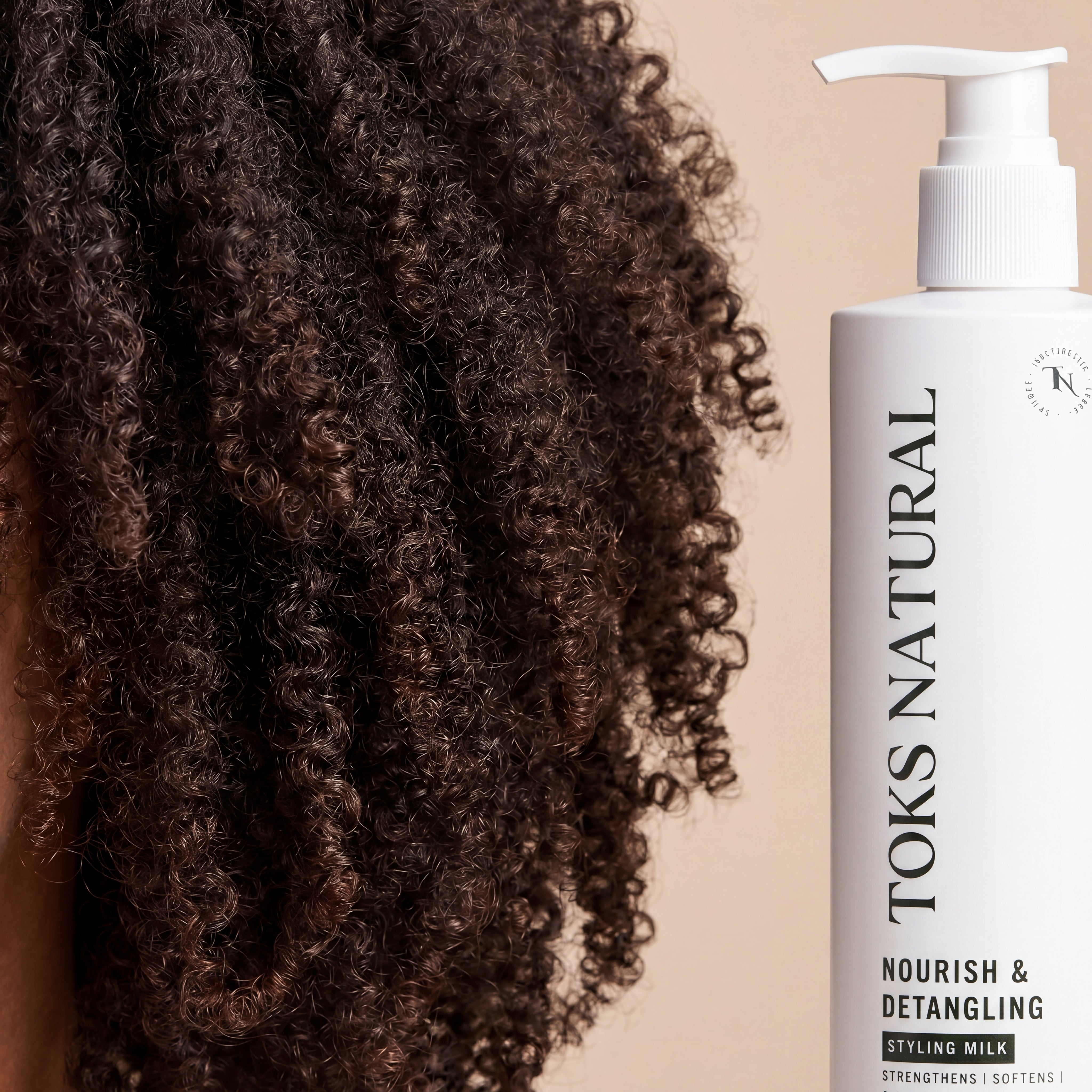 Toks Natural Nourish & Detangling Styling Milk bottle next to curly hair on a beige background