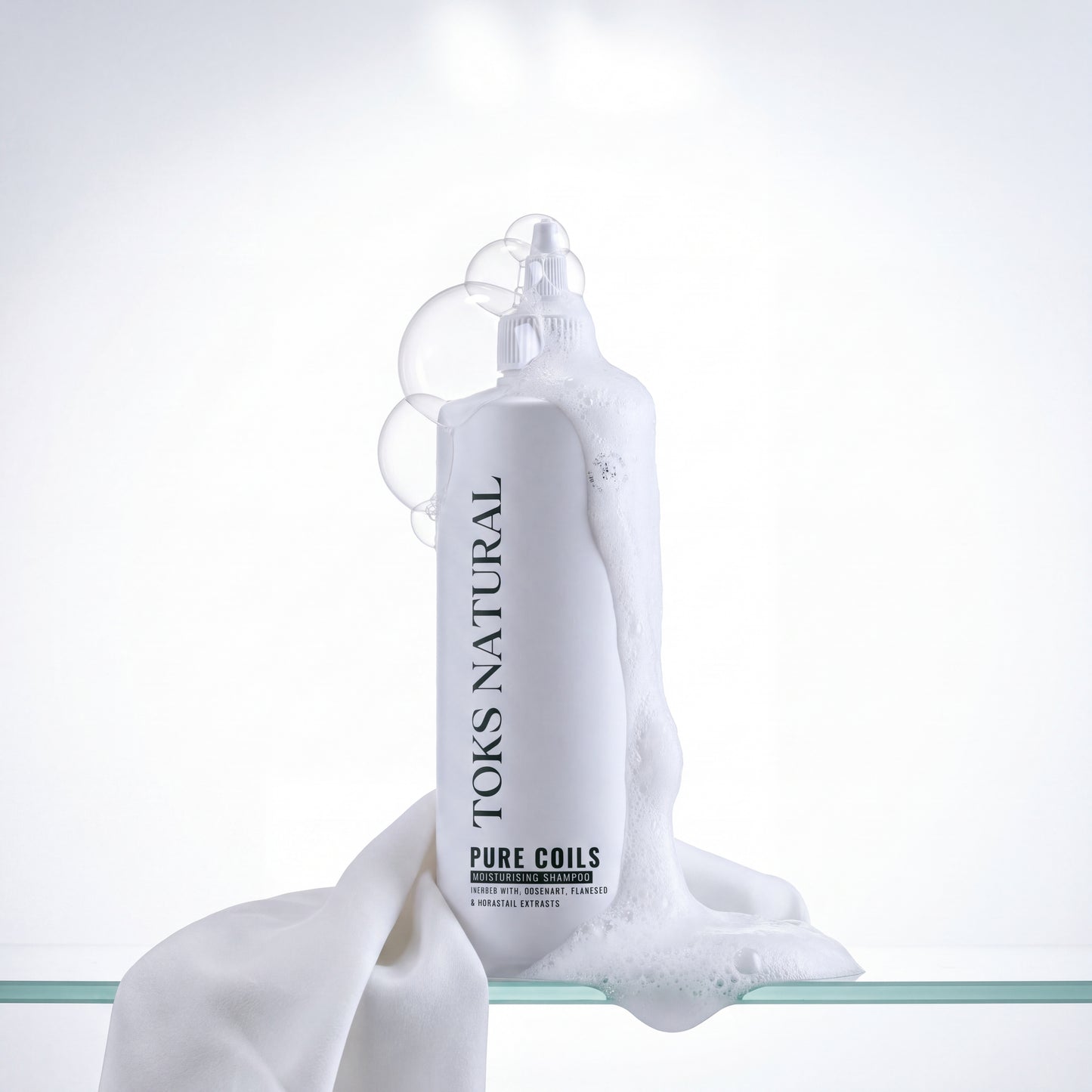 Toks Natural Pure Coils bottle with white fabric on a light gray background