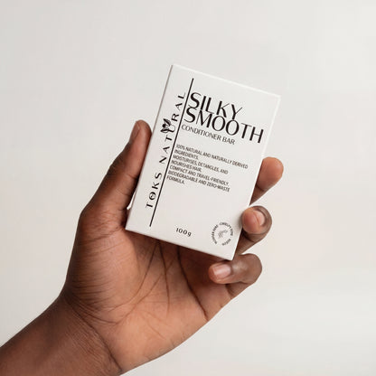 Hand holding a 'Silky Smooth' conditioner bar packaging against a white background