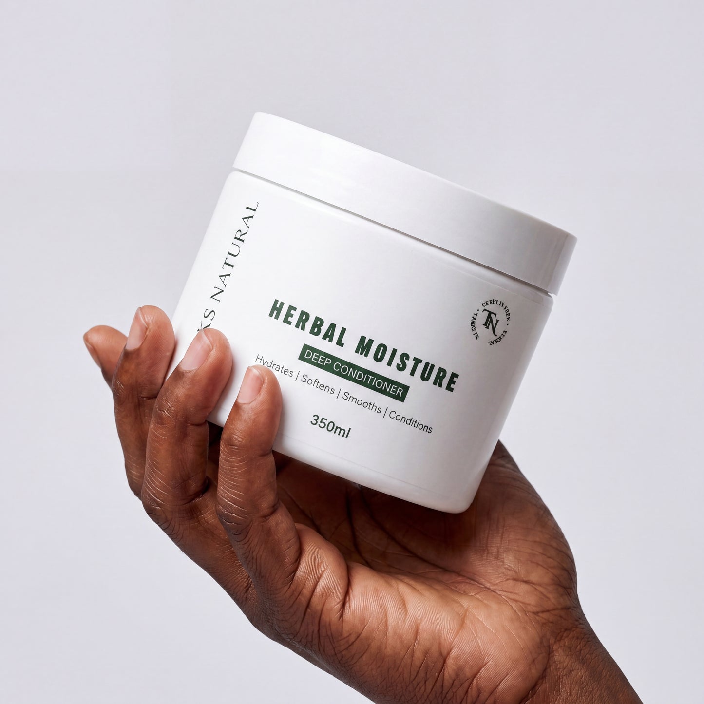 Hand holding a white jar labeled 'Herbal Moisture' against a light gray background