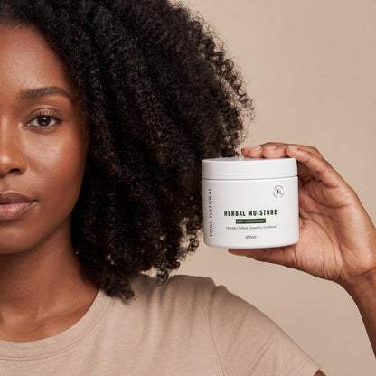 Woman holding a jar of 'Herbal Moisture' product with a neutral background