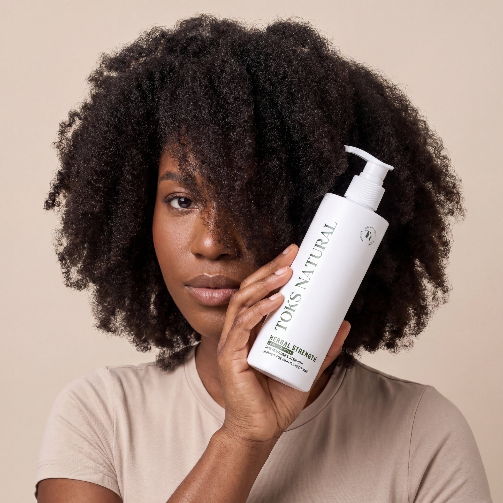toks natural herbal strength being held close up to a black female hair