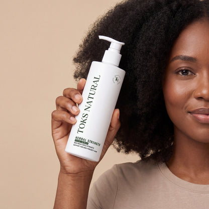 Woman holding a bottle of Toks Natural hair product against a beige background