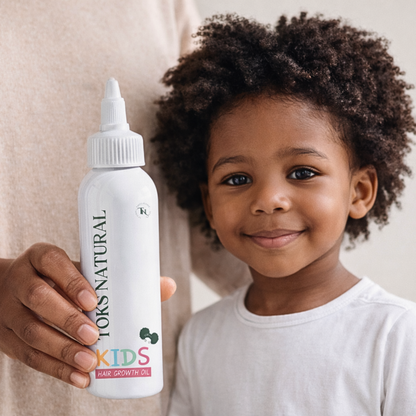 Child holding a bottle of YOKS NATURAL Kids Hair Growth Oil against a neutral background