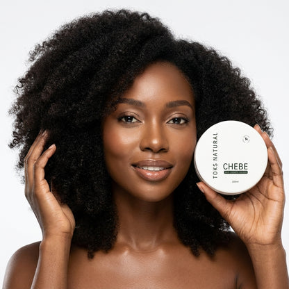 Woman holding a container of Toks Natural Chebe product against a neutral background